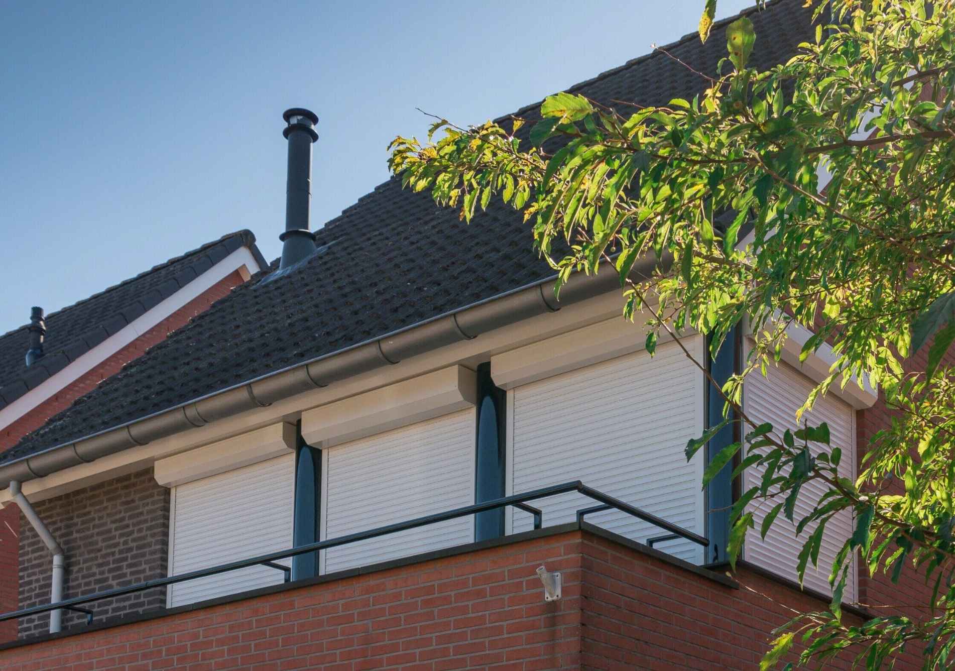 Moderne Nederlandse woning met rolluiken op de bovenverdieping.