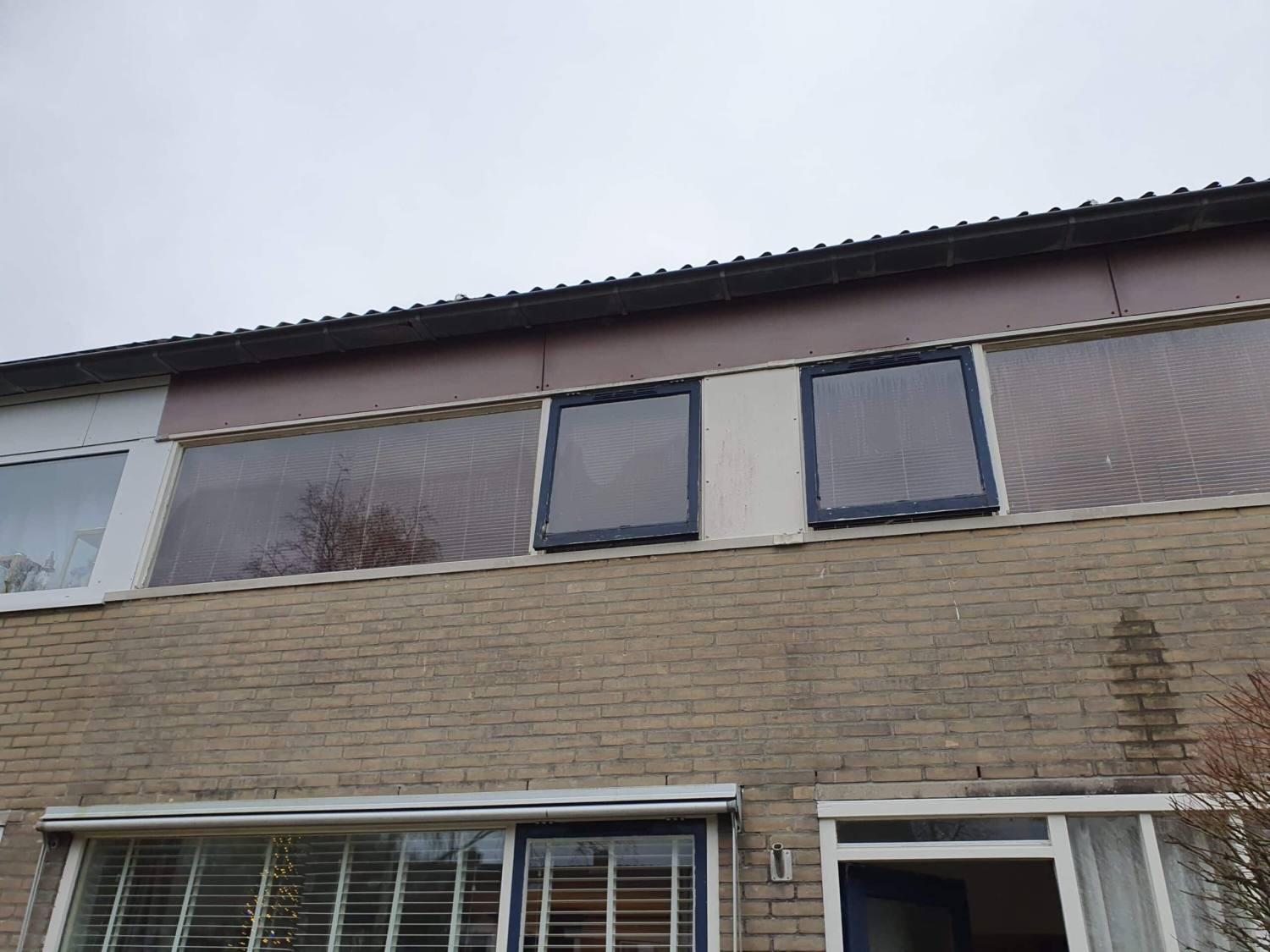 Bovenverdieping verouderde houten kozijnen