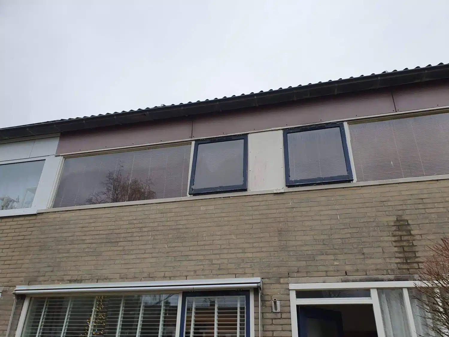 Bovenverdieping verouderde houten kozijnen