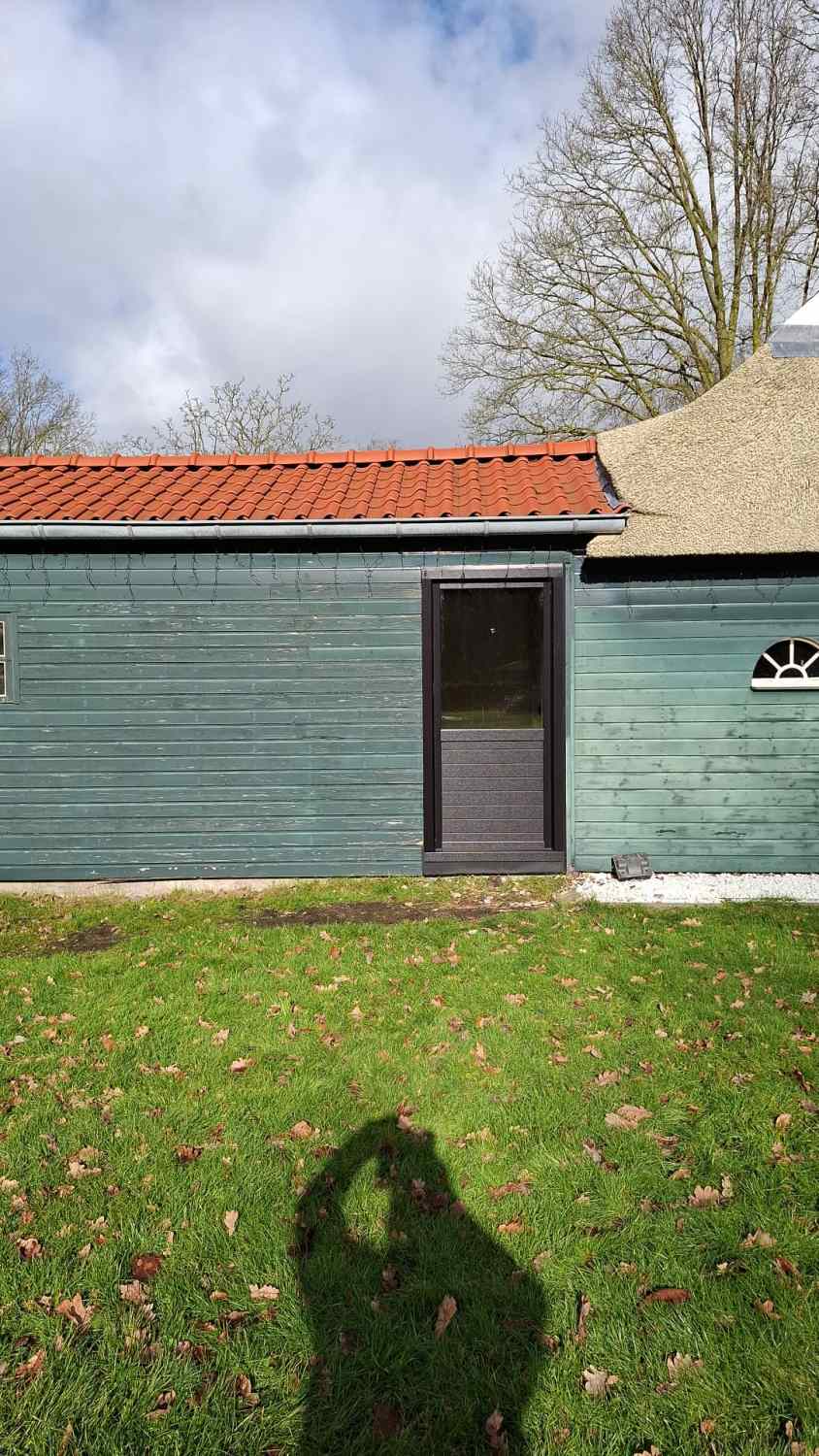 Achterzijde woning met kunststof deur in Waskemeer