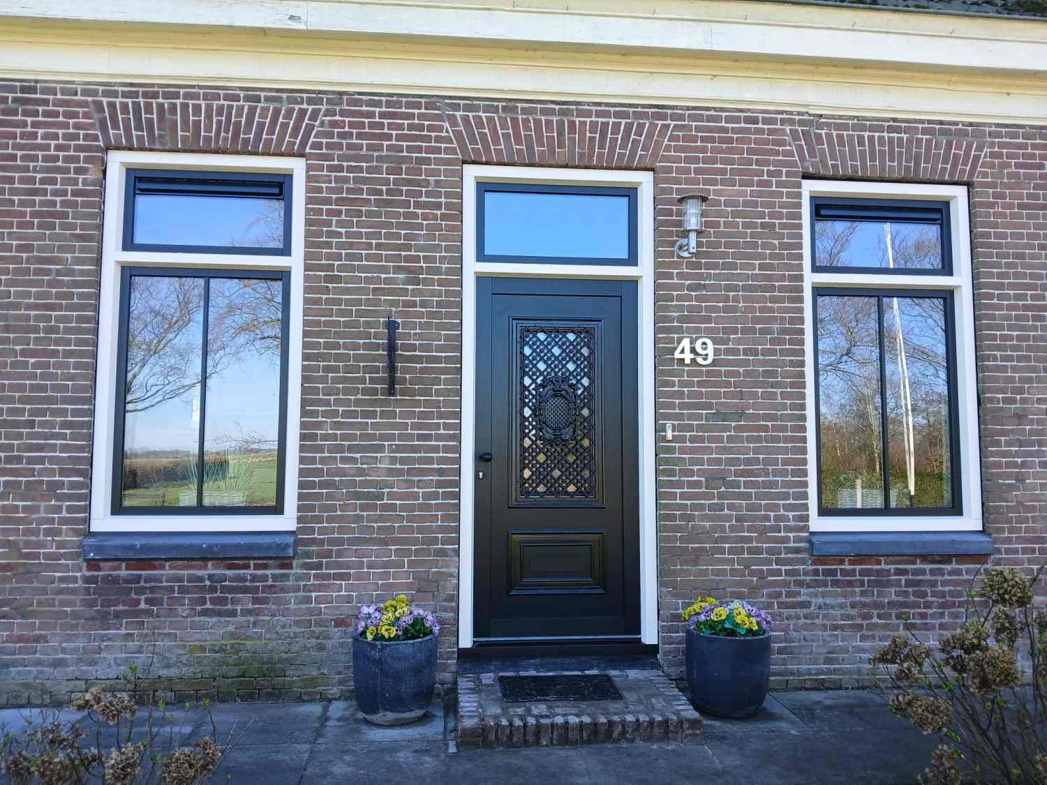 Authentieke gevel met kunststof kozijnen en sierlijke voordeur in Makkinga voor tijdloze uitstraling