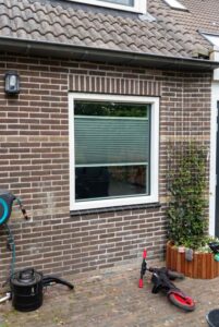 Wit kunststof kozijn RAL 9010 met groot raam aan tuinzijde van woning in Hoogeveen, door Markant Kozijnen.