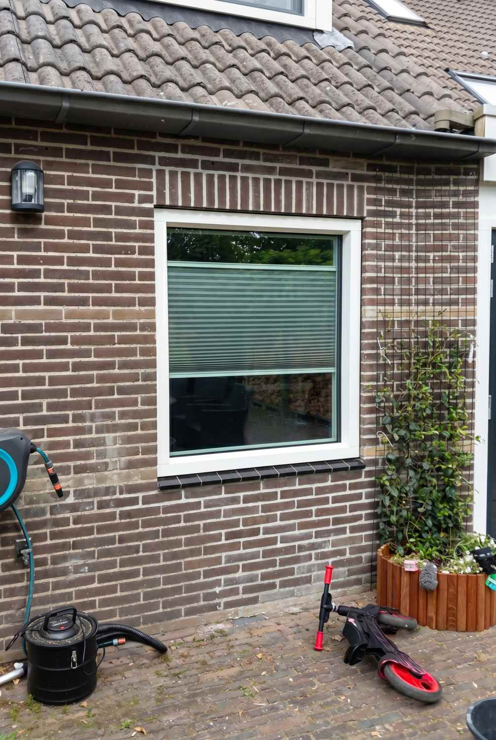 Wit kunststof kozijn RAL 9010 met groot raam aan tuinzijde van woning in Hoogeveen, door Markant Kozijnen.