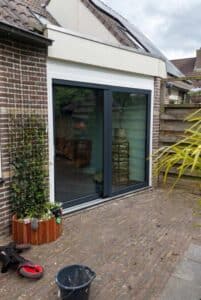 Antraciete kunststof schuifpui RAL 7016 aan achterzijde woning Hoogeveen, geplaatst door Markant Kozijnen.
