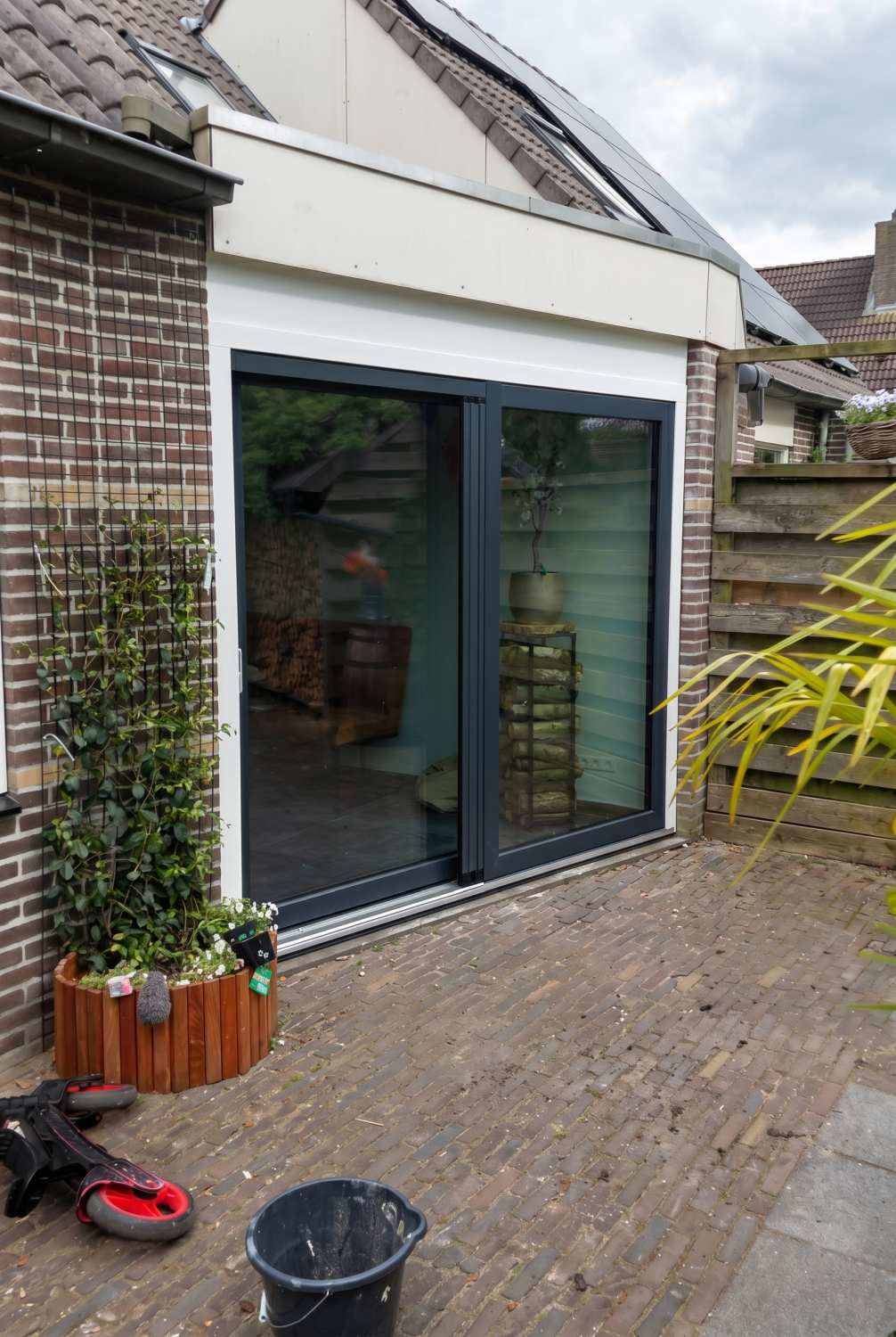 Antraciete kunststof schuifpui RAL 7016 aan achterzijde woning Hoogeveen, geplaatst door Markant Kozijnen.