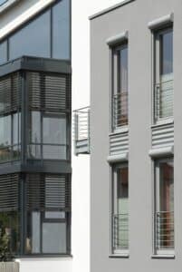Schüco kunststof kozijnen met antraciet lamellen en Franse balkons in moderne gevel, geleverd door Markant Kozijnen.