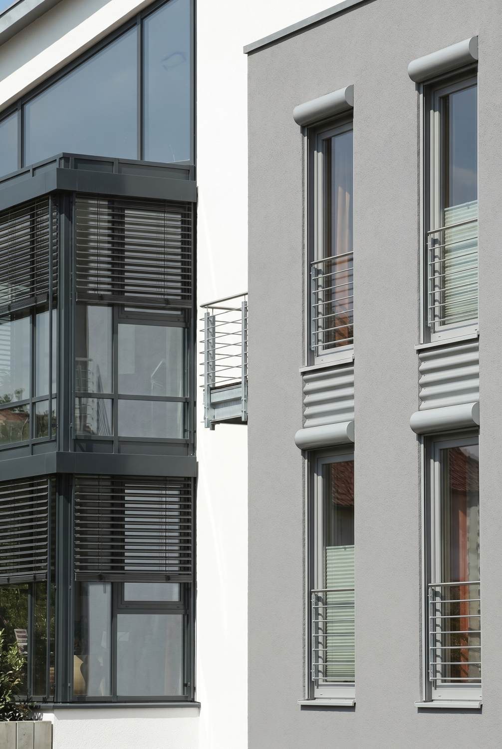Schüco kunststof kozijnen met antraciet lamellen en Franse balkons in moderne gevel, geleverd door Markant Kozijnen.
