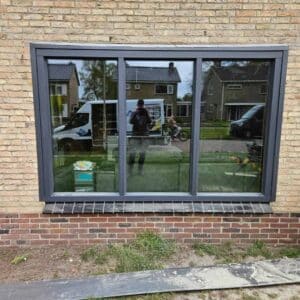 Kunststof schuifraam woonkamer in antracietgrijs RAL 7016 door Markant Kozijnen te Sint Nicolaasga.