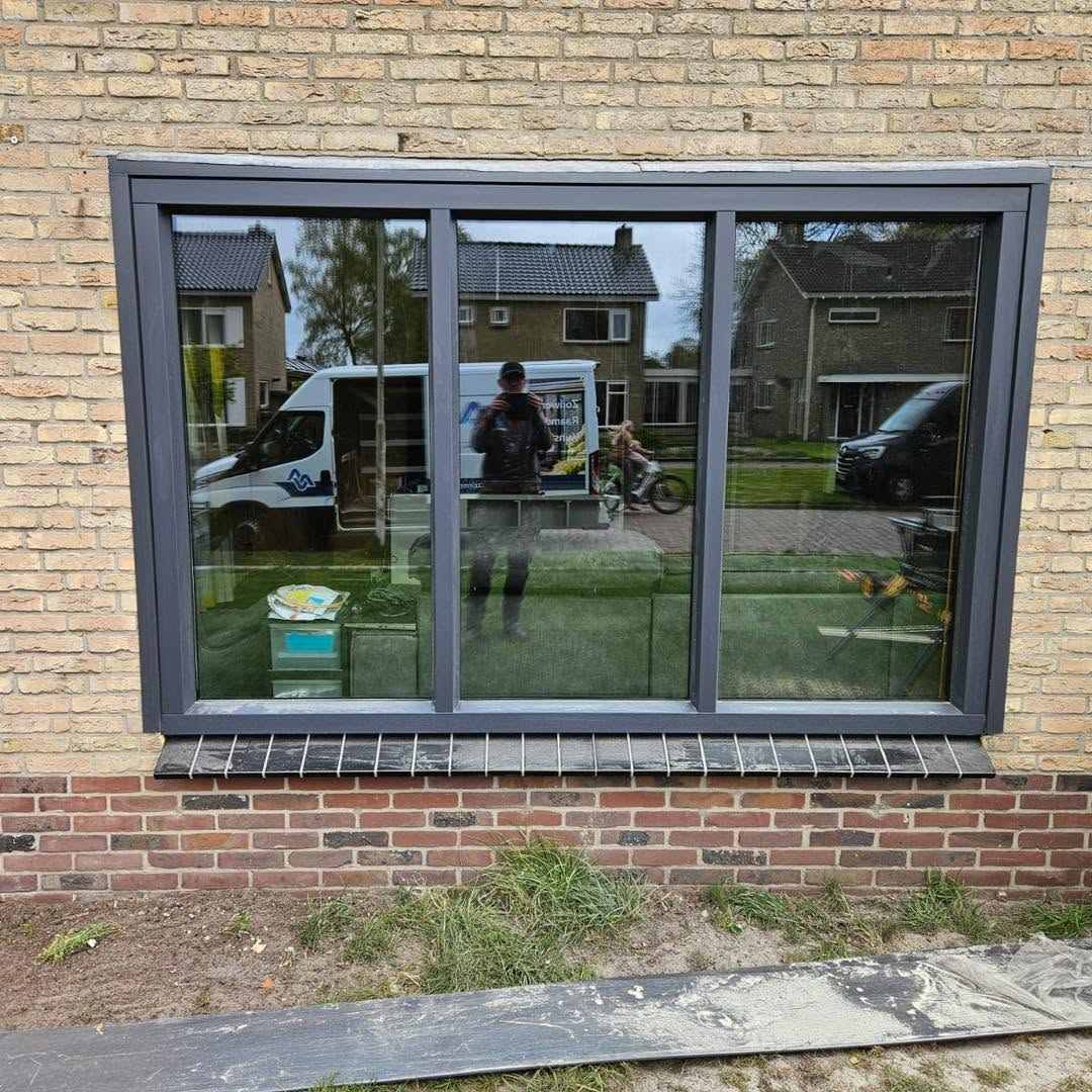 Kunststof schuifraam woonkamer in antracietgrijs RAL 7016 door Markant Kozijnen te Sint Nicolaasga.